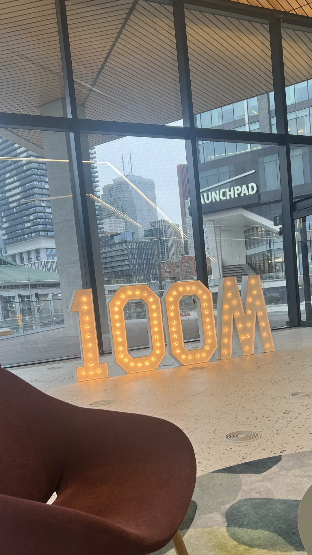 Cloud3 workspace lobby in Toronto with the 100M sign and downtown skyline
